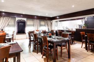 a dining room with wooden tables and chairs at InnJoy Boutique Hotel in Centurion