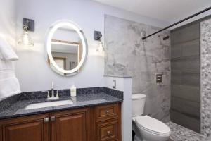 a bathroom with a sink and a toilet and a mirror at Woodbridge 21C in Snowmass Village