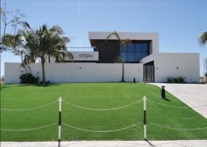 a house with a green lawn in front of it at G R A N D C H A L E T in Salalah