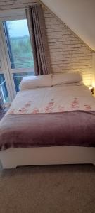 a bedroom with a large bed with a large window at Annaswood B&B in Cahir