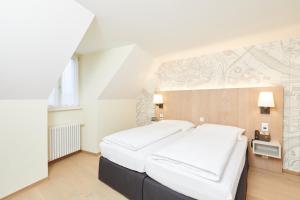 
a hotel room with a bed and a dresser at Kreuz Bern Modern City Hotel in Bern
