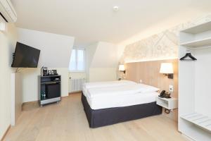 Postel nebo postele na pokoji v ubytování Kreuz Bern Modern City Hotel