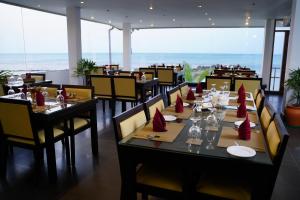 a restaurant with tables and chairs with red napkins at Village Hotel Northern Point in Point Pedro