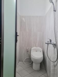 a bathroom with a toilet and a shower at RedDoorz Syariah @ Boemi Guesthouse Tasikmalaya in Tasikmalaya