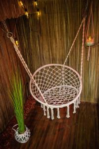 un'altalena bianca in una stanza con una pianta in vaso di Aux 3 Nuances Suites Privatives & Spa a Calais Altre 21 foto