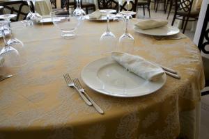 Hotel Del Sole في مارغريتا دي سافويا: طاولة عليها صحن ابيض عليها منديل