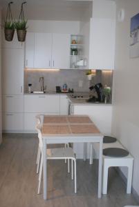 奧斯坦德的住宿－Sea Side，白色的厨房配有桌椅和水槽
