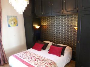a bedroom with a bed with red pillows at Hôtel Le Bretagne in Vannes