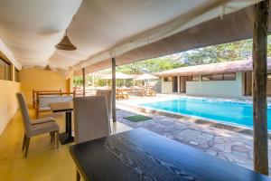 a dining room with a table and a swimming pool at PrideInn Mara Camp & Cottages in Talek