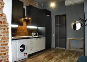 a kitchen with a washing machine in a room at Dorosh-HOME квартира-студія в центрі Львова in Lviv