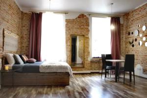 a bedroom with a bed and a brick wall at Dorosh-HOME квартира-студія в центрі Львова in Lviv