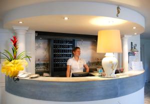 Eine Frau, die an einem Tresen in einem Zimmer steht. in der Unterkunft Hotel Cavalluccio Marino in Santa Marinella