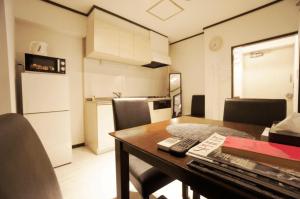 a small kitchen with a table and a room with a kitchen at H2O Stay Kikukawa Woody Sunheim #201 in Tokyo