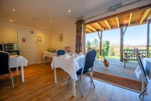 a dining room with tables and chairs and a large window at Oakside Lodge Guest House in Canterbury