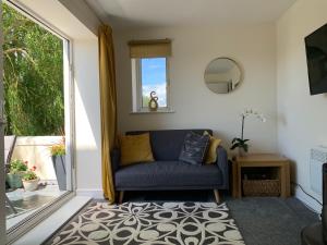 sala de estar con sofá azul y ventana en Balcony Apartment near Skegness Beach & Town en Skegness