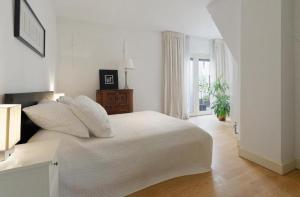 Luxury Prinsengracht Canal House Jordan Area في أمستردام: غرفة نوم بيضاء مع سرير أبيض ونافذة