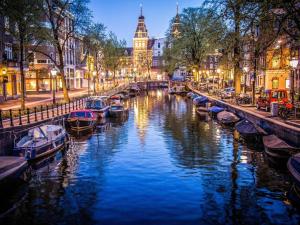 Un canal con barcos en una ciudad por la noche en Luxury Prinsengracht Canal House Jordan Area en Ámsterdam