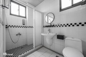 a white bathroom with a sink and a toilet at H& Taitung Feng Lin Resort Hotel in Taitung City