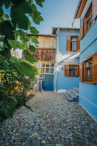 - un bâtiment bleu et blanc avec un portail et une cour dans l'établissement Pensiunea Zidul Cetății, à Sighişoara
