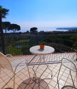 una mesa y sillas en un patio con vistas al océano en Villa Mayoti B&B, en Manerba del Garda