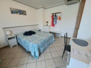 a bedroom with a bed with a blue comforter at Villa Mayoti B&B in Manerba del Garda