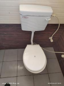 a white toilet sitting in a bathroom with at HOTEL PURNIMA PALACE in Fatehpur