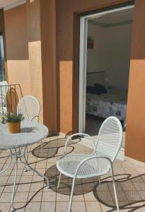 trzy krzesła i stół na patio w obiekcie Villa Mayoti B&B w Manerba del Garda