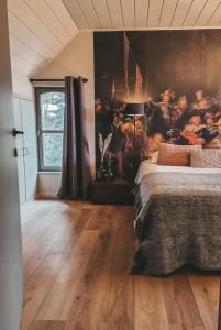 um quarto com uma cama grande e uma pintura na parede em B&B Bergenhof em Hoogstraten