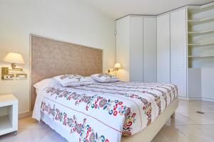 a bedroom with a bed with a floral bedspread at Villa Azzurra Depandance con piscina in Desenzano del Garda
