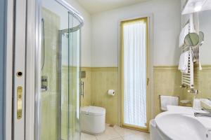 a bathroom with a shower and a toilet and a sink at Villa Azzurra Depandance con piscina in Desenzano del Garda +11 photos