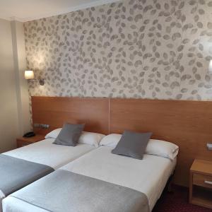 2 camas en una habitación de hotel con pared en Peregrina Hotel, en Sanxenxo