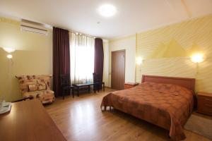 a hotel room with a bed and a desk at Hotel Odisseya in Ryazan