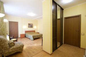 a bedroom with a bed and a couch in a room at Hotel Odisseya in Ryazan