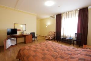 a hotel room with a bedroom with a bed and a television at Hotel Odisseya in Ryazan