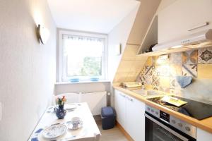 a small kitchen with a sink and a stove at FeWo-2-OG-rechts in Sankt Peter-Ording