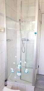 - une douche dans une salle de bains avec des cercles bleus au sol dans l'établissement FeWo-2-OG-rechts, à Sankt Peter-Ording