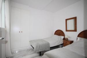 een slaapkamer met 2 bedden en een spiegel bij Bear Holiday - Apartment Beau with Sea View in Moraira near the Beach in Moraira