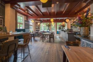 a restaurant with wooden floors and tables and chairs at Grandcafé Boutique Hotel Eemland in Eemnes