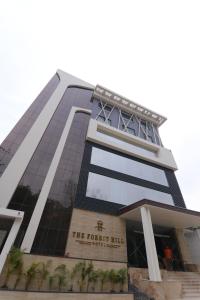 um edifício alto com uma placa na frente em The Forest Hill Hotel em Haridwar