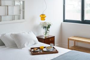 a tray of food on a bed with orange juice at Herdade do Ananás in Ponta Delgada
