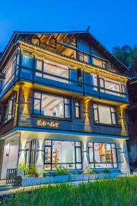 a large wooden building with lights on at 肇兴溪舍山堂 Creekside Inn in Liping