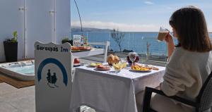 una mujer sentada en una mesa con un plato de comida en Garoupas Inn en Ponta Delgada