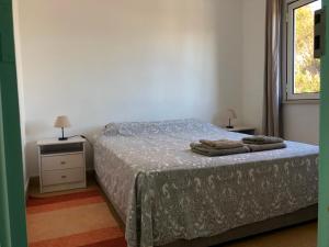 1 dormitorio con 1 cama con 2 toallas en Casa do Viajante - Family, en Zambujeira do Mar