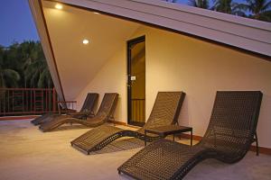 a row of chairs sitting on a balcony at Layang Layang Home in El Nido