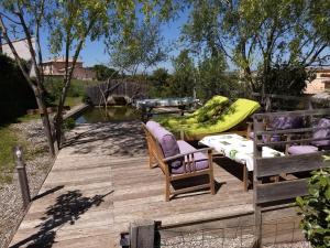 una terraza de madera con 2 sillas y una hamaca en Les Terrasses de Valensole en Valensole