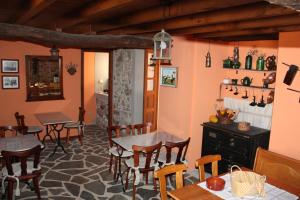 een eetkamer met tafels en stoelen en een open haard bij Casa Rural A Pasada in Cedeira