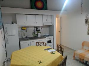 una cocina con una mesa con un mantel amarillo. en Mendoza Departamento 4 o 5 personas en Mendoza