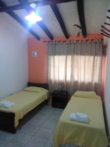 2 camas en una habitación con techos rojos y azules en Mendoza Departamento 4 o 5 personas en Mendoza