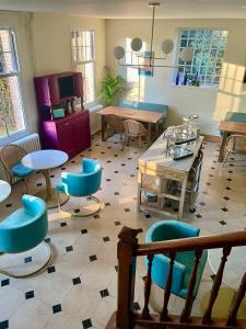 Pokój z niebieskimi krzesłami i stołami w pokoju w obiekcie Aux Jolies Sources w mieście Saint-Aubin-sur-Scie
