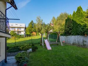 a backyard with a swing set in the grass at Willa Malinowscy in Szczawnica